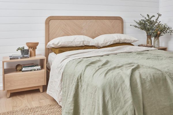 A Timber bedhead with a herringbone design styled with soft linen bedding