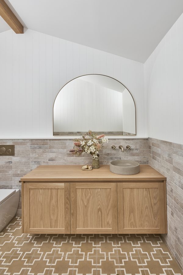 Timber arched mirror over a timber bathroom vanity