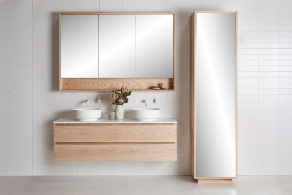A tall timber tall boy tower, wall hung vanity and mirrored cabinet in a bathroom
