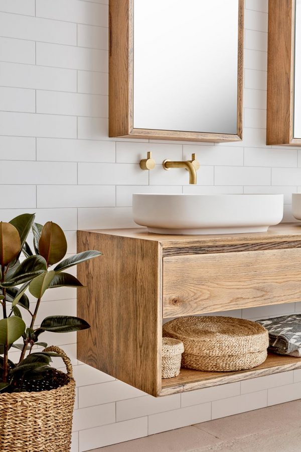 A mirrored bathroom cabinet hung over a single timber wall hung vanity