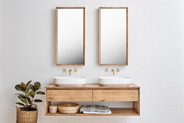 Two mirrored bathroom cabinets hung over a double sink wall hung bathroom vanity