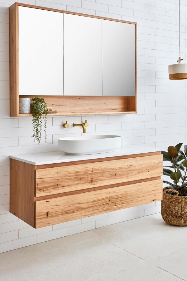 Mirrored bathroom cabinet with a storage shelf above a single sink floating timber vanity with two drawers. The timber vanity has a single sink with a stone benchtop.