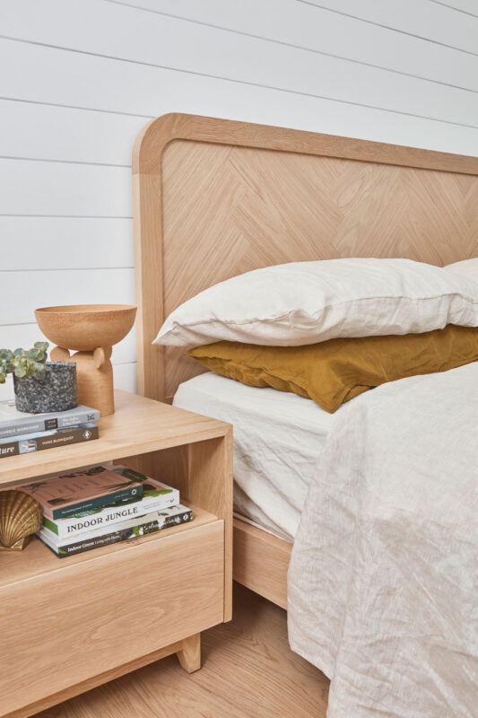 Timber bedside table styled in a coastal style bedroom