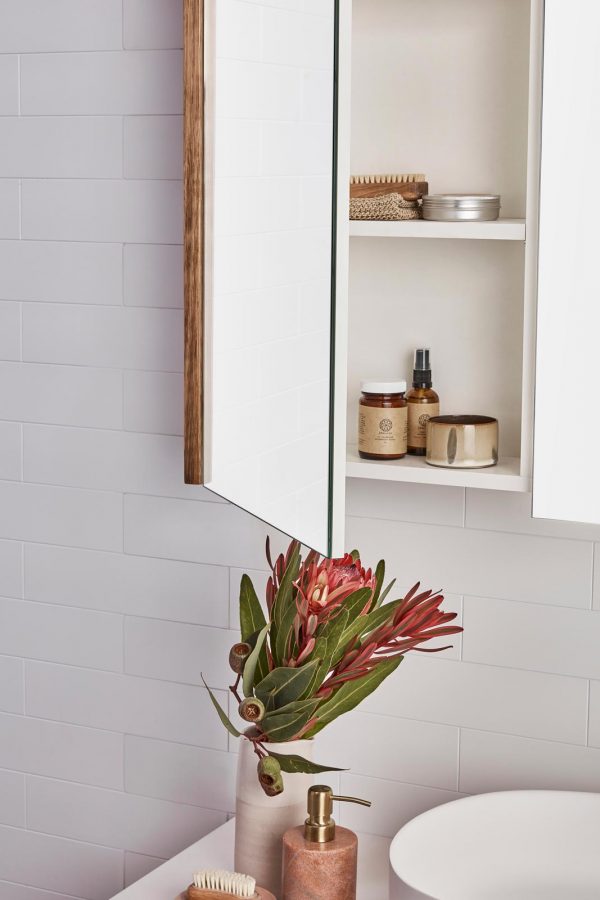 Mirrored bathroom cabinet open door over a timber vanity | Storage solutions for a coastal bathroom