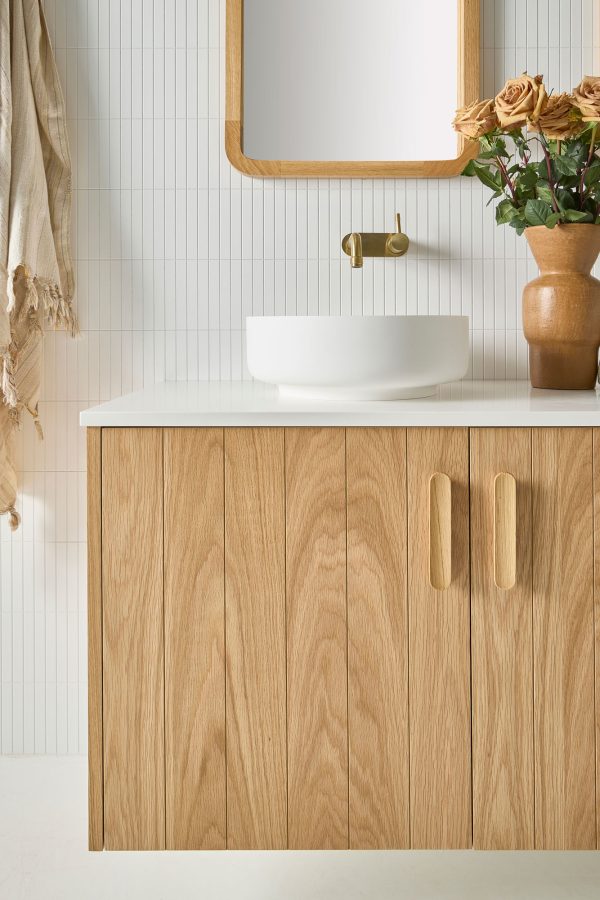 Coastal Australian Bathroom, this real timber vanity piece has a solid white bench top with a white sink and gold tap-ware. This all sits underneath a rectangular mirror | Loughlin Furniture