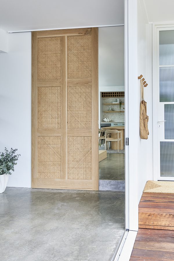 Pacific Internal door in a home with the kitchen showing being the custom made door with open weave rattan.