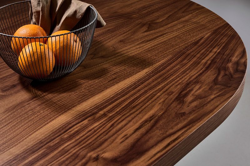 A custom made timber table from Loughlin Furniture. A walnut timber table with a basket of oranges on top.