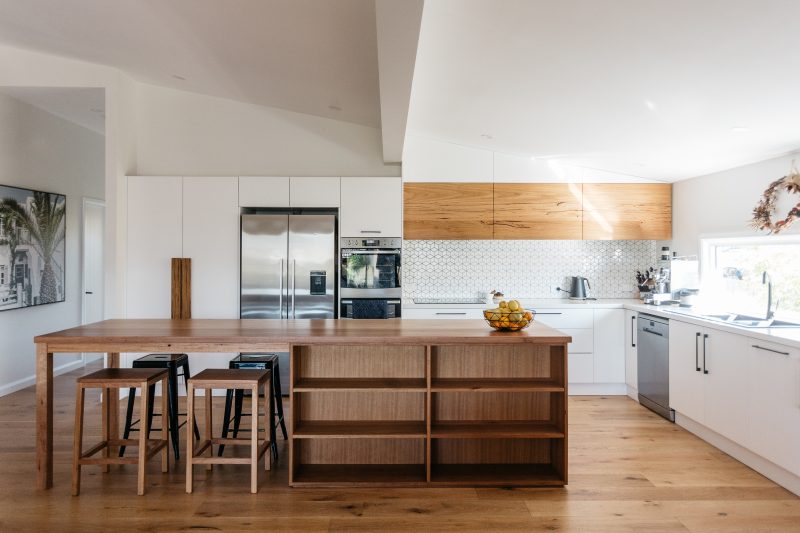 A kitchen bench top with stool seating and open cupboard space | Kitchen timber joinery