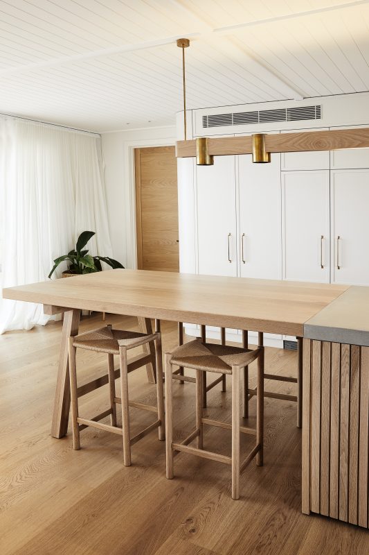 A kitchen bench top in timber and timber stools