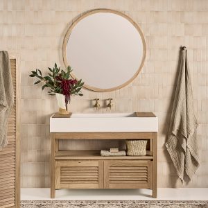 The timber bathroom vanity with cupboard storage and open shelves styled under a round mirror.